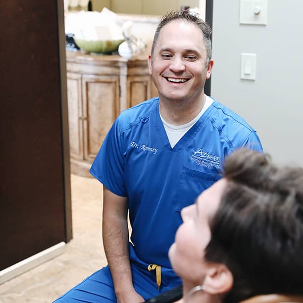 Dr. Gregory Romney talking with a dental patient